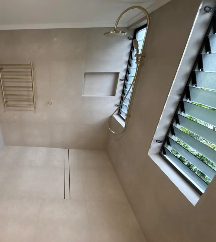 Open walk-in shower with a linear drain, tiled niche and large-format grey tiles