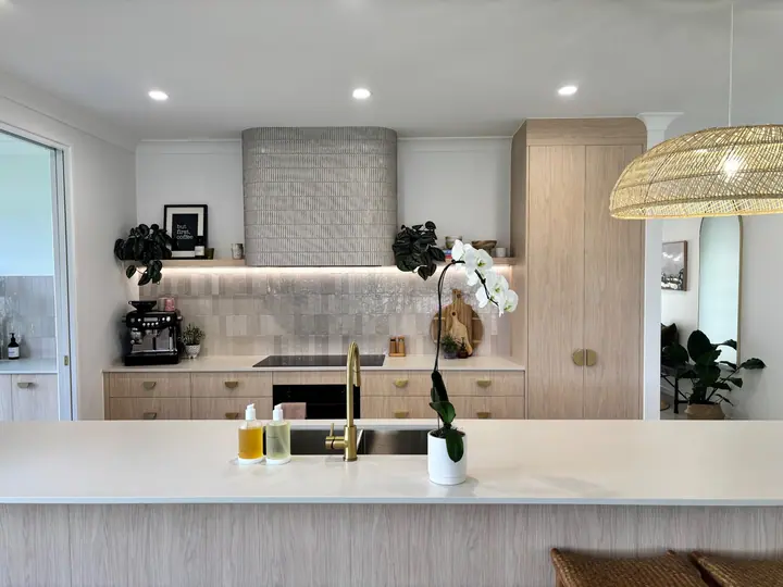 Kitchen with a tiled rangehood surround and gloss tiled splashback