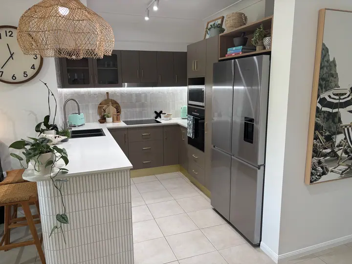 Kitchen with a tiled splashback and cream floor tiles