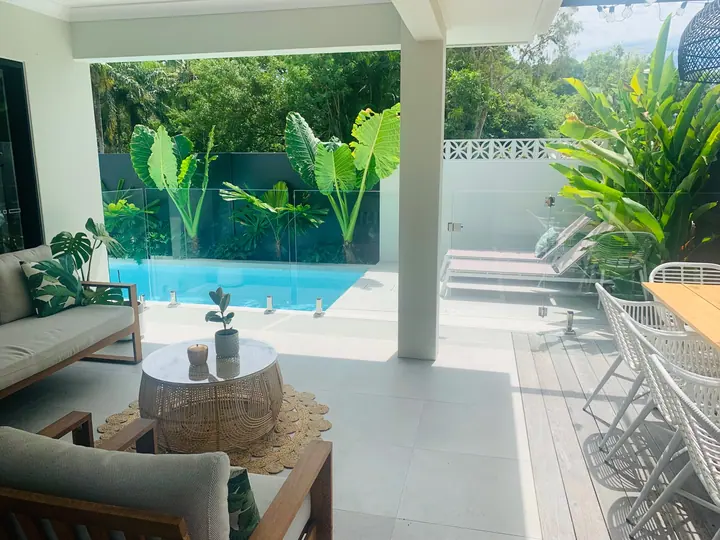 Tiled outdoor entertaining area beside a swimming pool