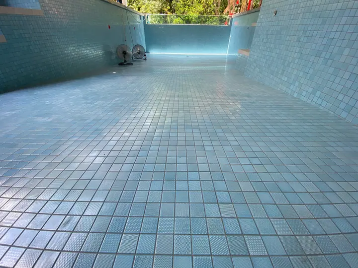 Pool floor and walls fully tiled in aqua mosaic tiles