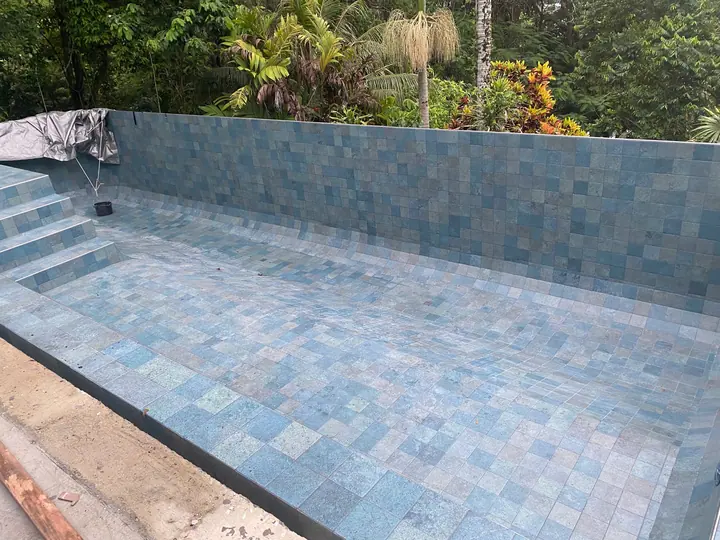 Pool interior tiled in green-blue tiles before filling