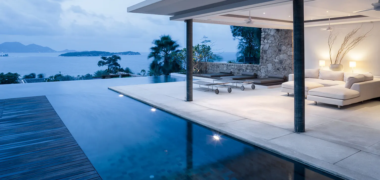 Tiled pool terrace and outdoor living area overlooking the ocean